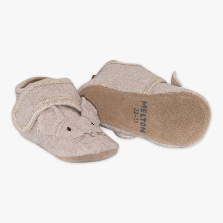 Et par lys beige baby tøfler i filt med brodert kaninansikt, ører og borrelåsbånd.