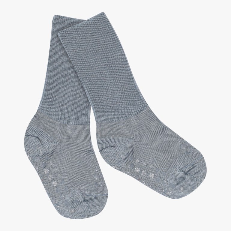 Et par blågrå antiskli-sokker for baby med ribbet tekstur, vist liggende flatt.