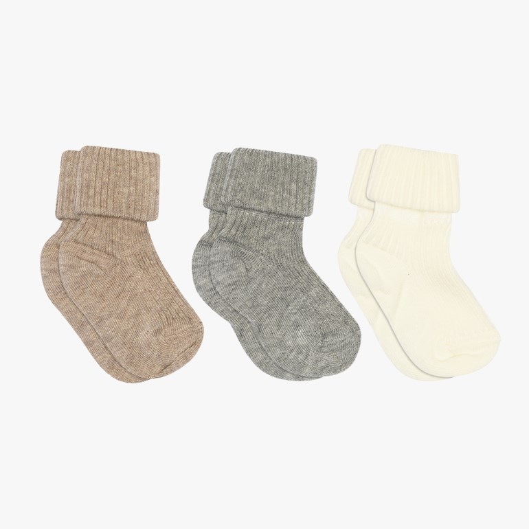 Tre par babystrømper i lysebrun, grå og off-white med ribbet strikk og brettede mansjetter.