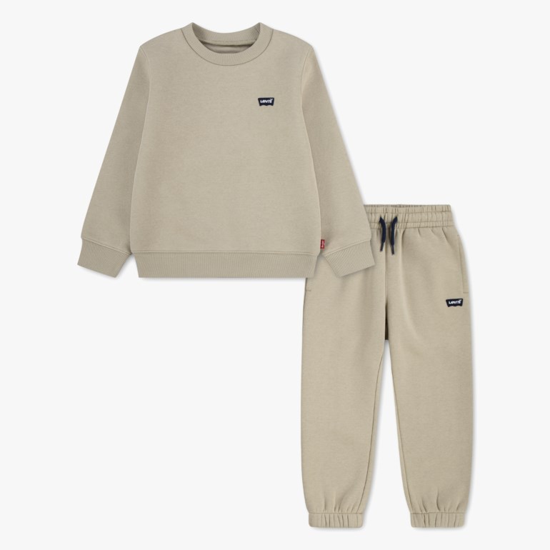 Barnes beige langermet genser med rund hals og matchende joggebukse med marineblå snøring, forfra.