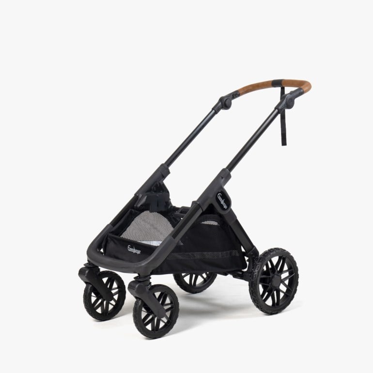 Svart barnevognchassis med fire hjul, en svart nettingkurv og et brunt lær-lignende håndtak mot hvit bakgrunn.