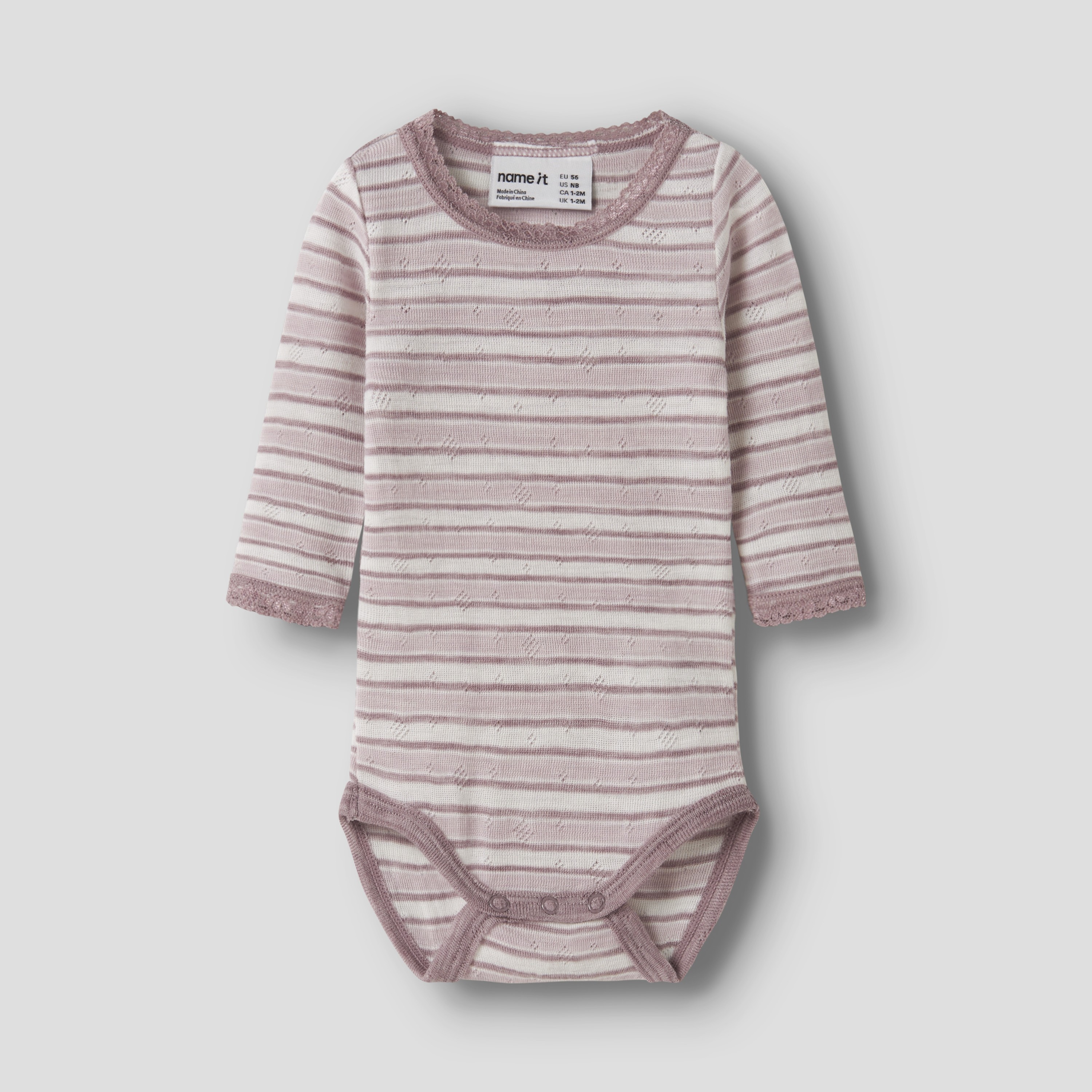 Frontvisning av en langermet babybody i rosa og hvit stripete stoff med blondedetaljer, teksturert mønster og trykknapper.