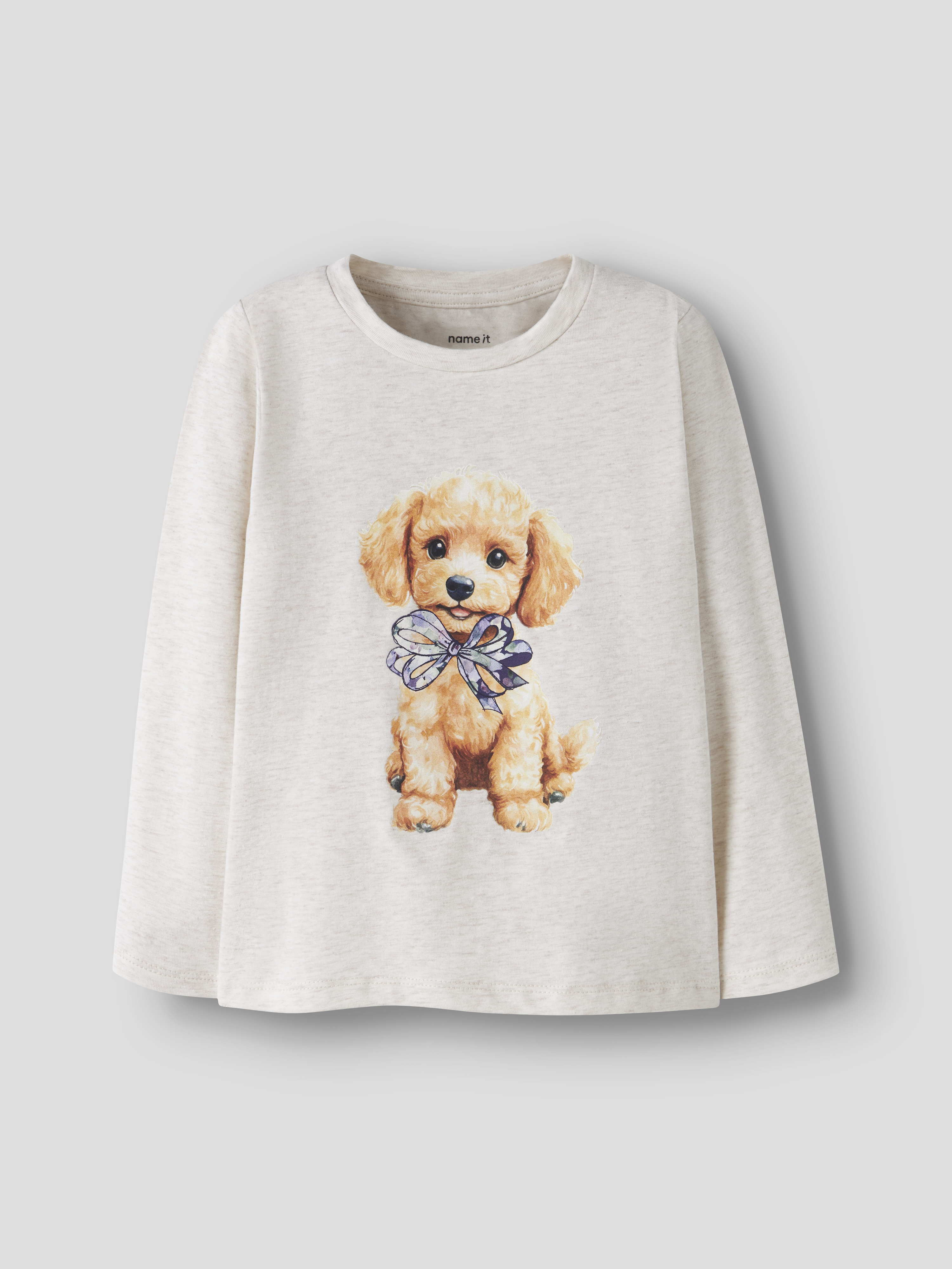 Barns beige melange langermet t-skjorte med trykk av en brun valp som har en sløyfe foran.