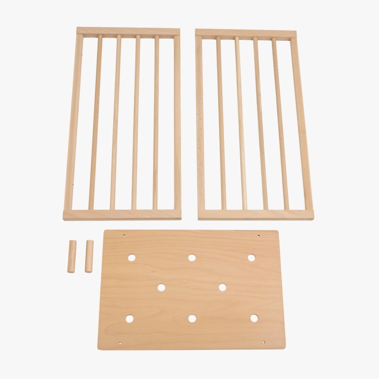 Lys treplate med åtte runde hull, to sidepaneler med spiler og to små treplugger.