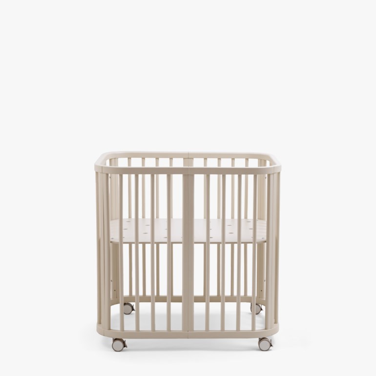 Beige avrundet babyseng med sprinkelsider og hjul, sett forfra.