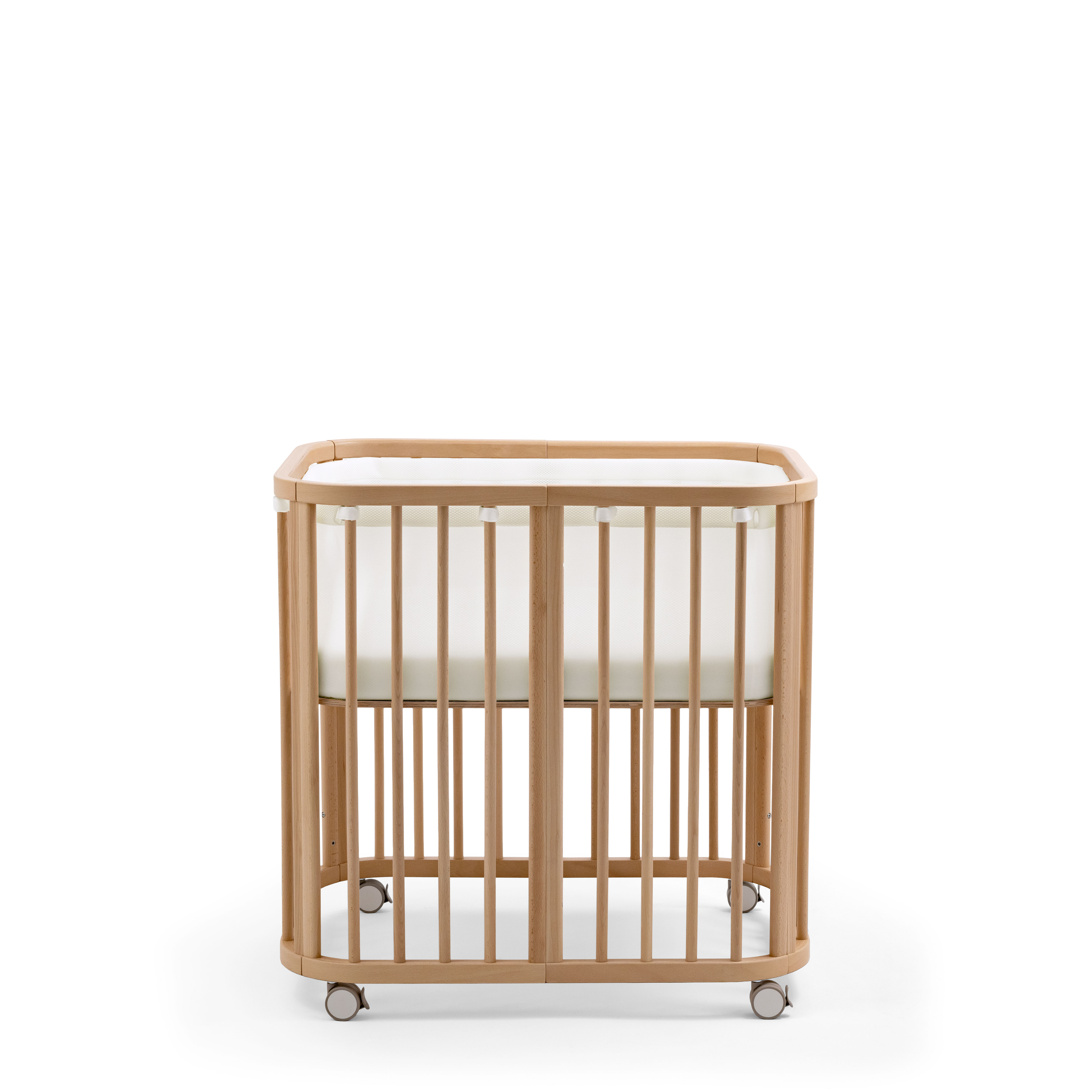 Babyseng i naturlig tre med avrundede kanter, hvite nettingvegger, en hvit madrass og grå hjul.