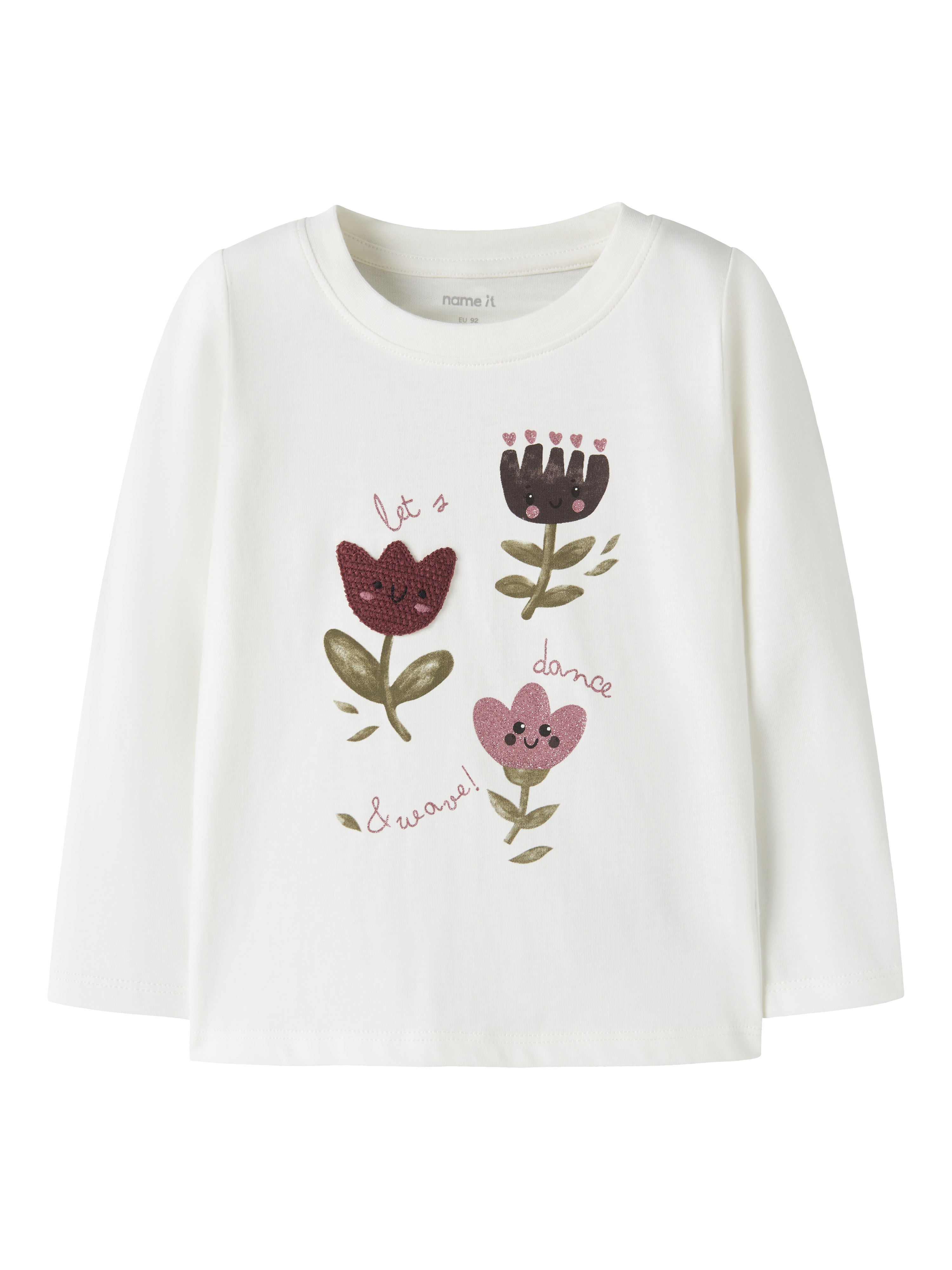 Hvit langermet barnetopp med rund hals og fargerikt blomstertrykk med tekst.