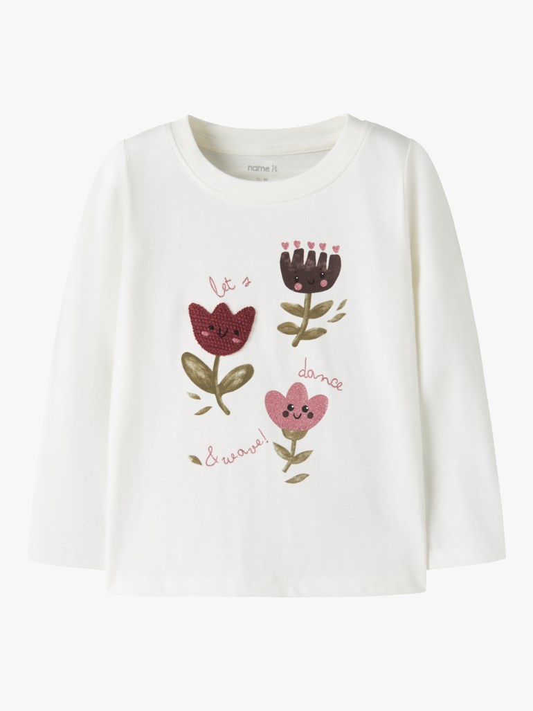 Hvit langermet barnetopp med rund hals og fargerikt blomstertrykk med tekst.