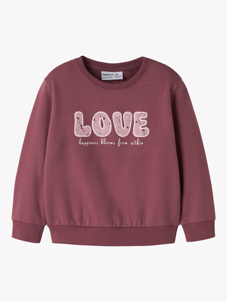 Barnas mauve genser framfra med blomstrete 'LOVE'-trykk og inspirerende tekst under.