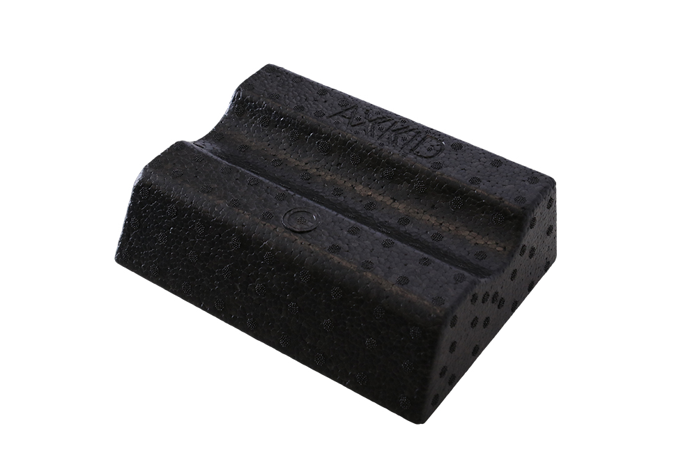 Svart teksturert skumblokk med to buede kanaler og en preget 'AXKID' logo.