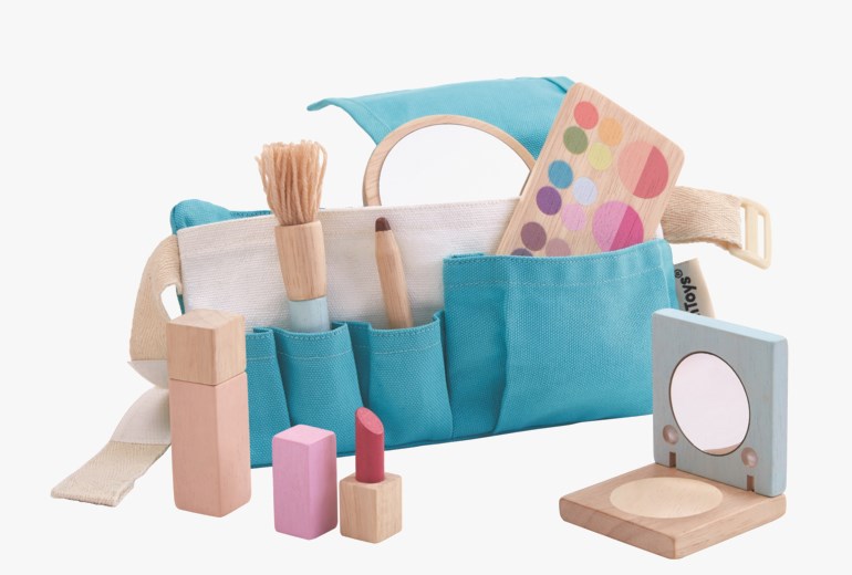 Turkis kanvas leke sminkepung med trebørste, eyeliner, øyenskyggepalett, foundation, rouge, leppestift og speil.