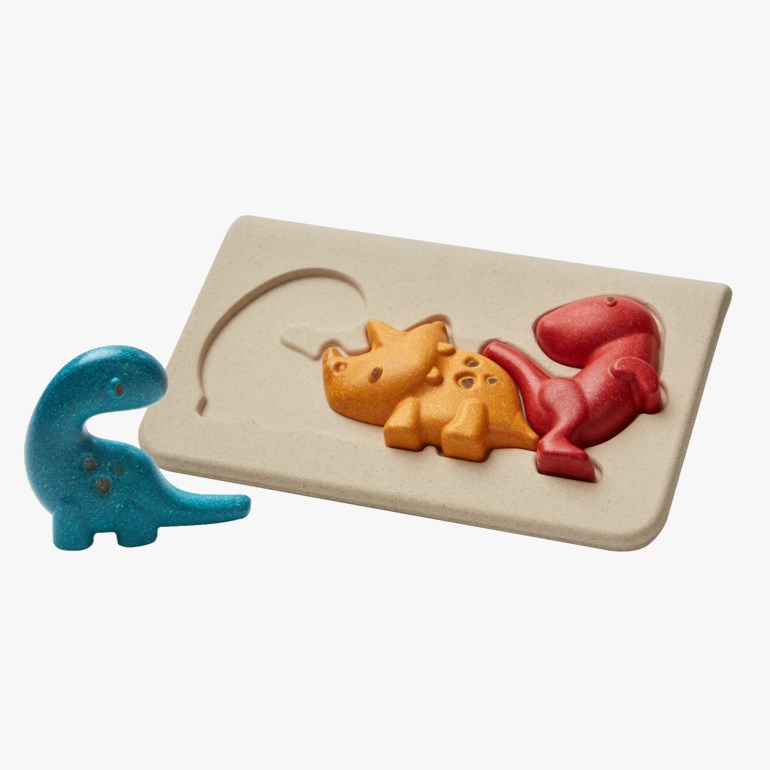 Et lys brunt dinosaurpuslespillbrett med røde og oransje dinosaurbiter, pluss en blå dinosaurleke.