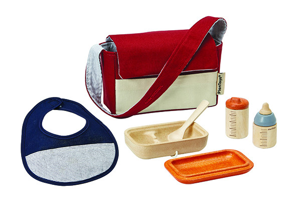 Rød og kremfarget messengerveske med stripete fôr, blå smekke, beige bolle med skje, oransje brett, to trefalsker.