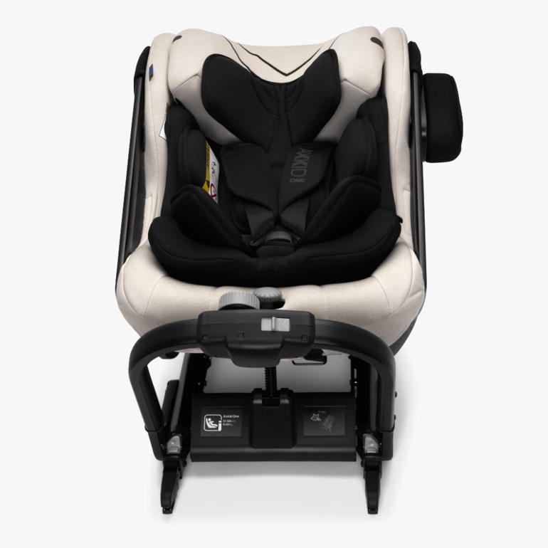 En beige og svart bilbarnestol for baby eller barn, med svart sele og justerbar base.