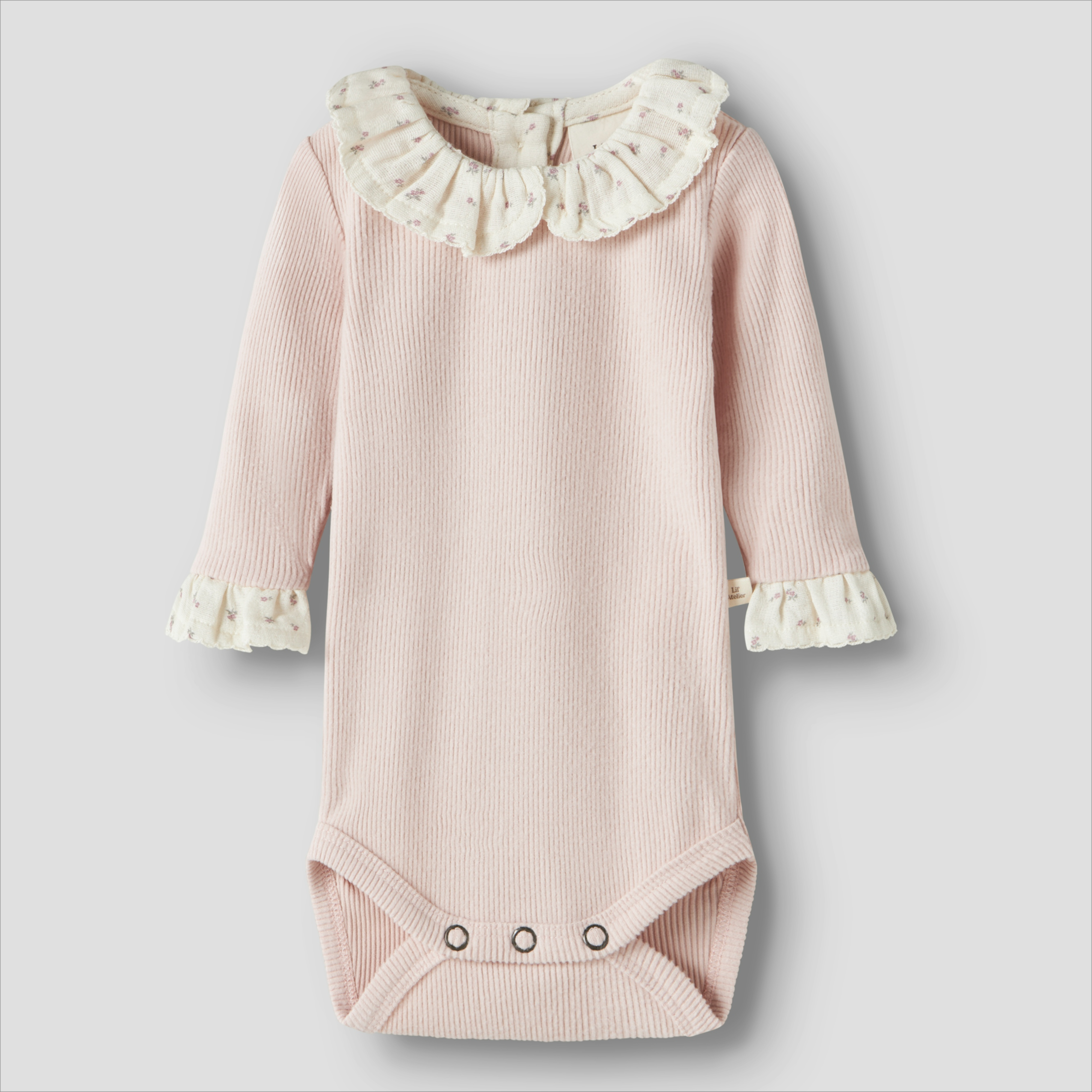 Baby rosa ribbet langermet body med volangkrage og mansjetter med blomstermønster, trykknapper i skrittet.