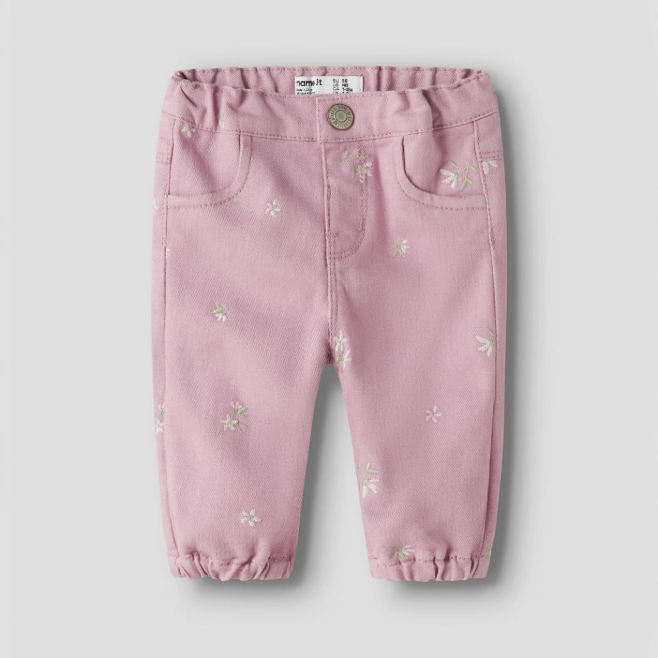 Babypikebukser i rosa med små blomsterbroderier, elastisk midje og nederkanter, og frontlommer.