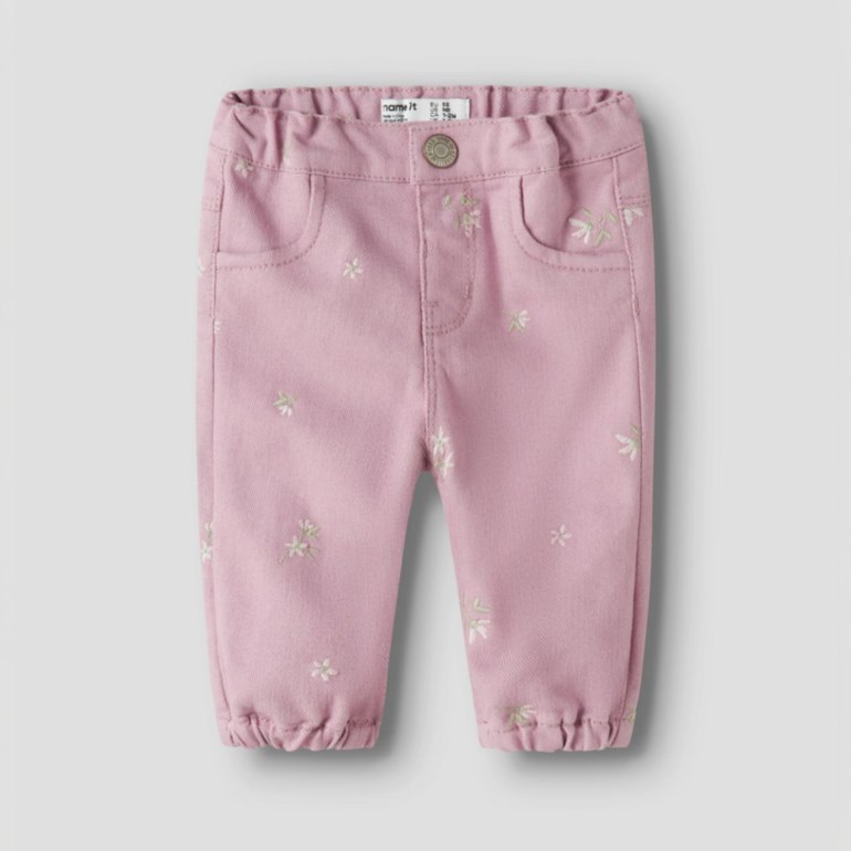 Babypikebukser i rosa med små blomsterbroderier, elastisk midje og nederkanter, og frontlommer.