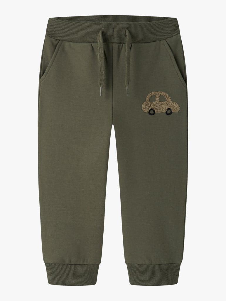 Mørkegrønne barnesweatpants med ribbestrikket midje, snøring, sidelommer og en brun bilapplikasjon.
