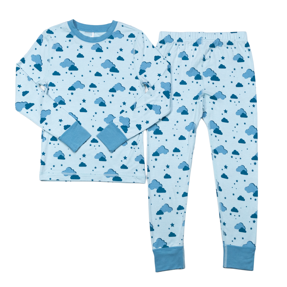 Lys blå barne pyjamas med langermet topp og bukse med mørkeblått sky- og stjernemønster.