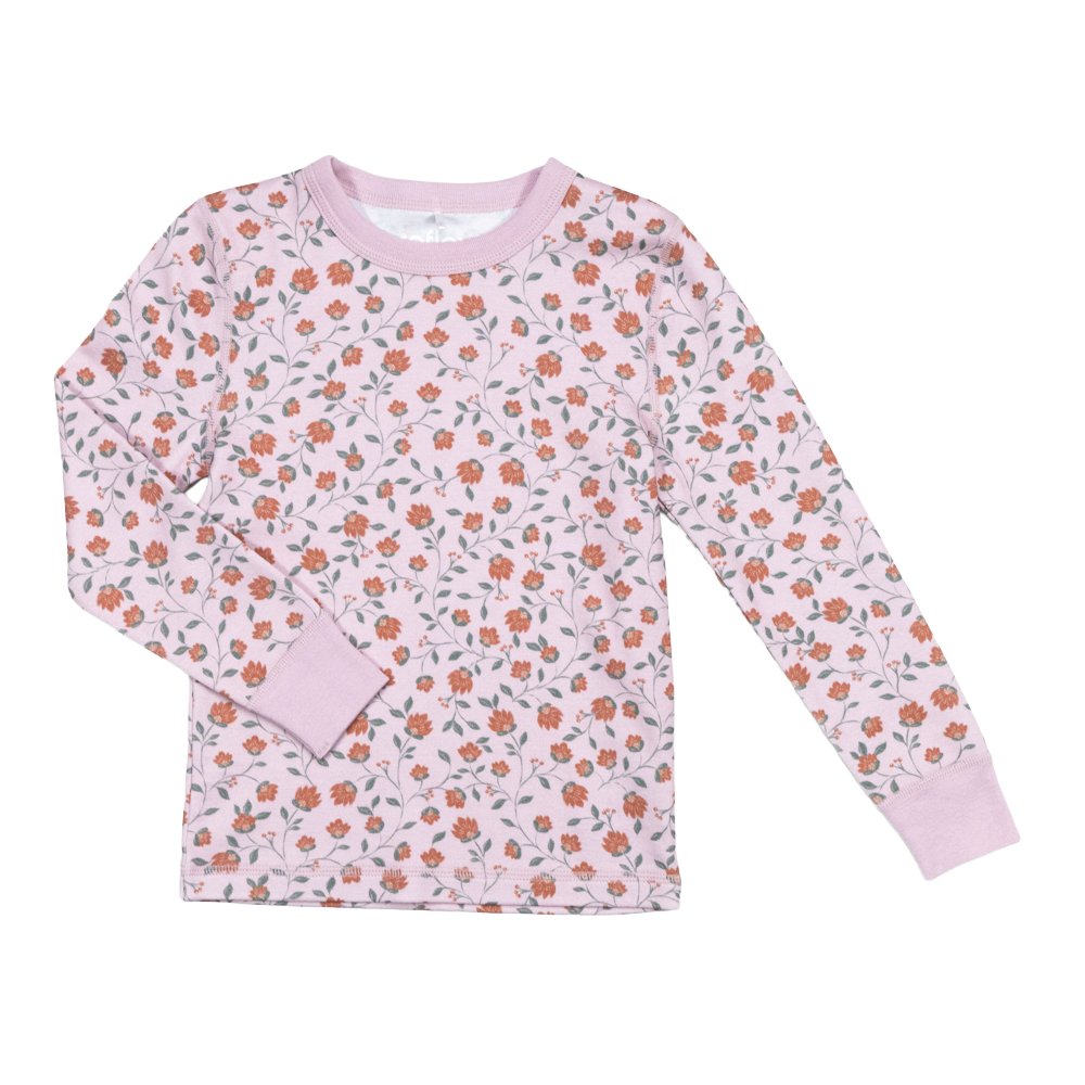 Langermet rosa barnetopp med heldekkende oransje blomstermønster og rosa ribbestrikkede mansjetter og krage.
