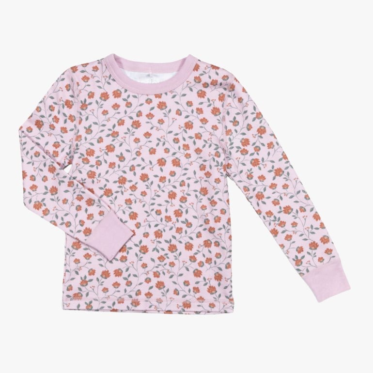 Langermet rosa barnetopp med heldekkende oransje blomstermønster og rosa ribbestrikkede mansjetter og krage.