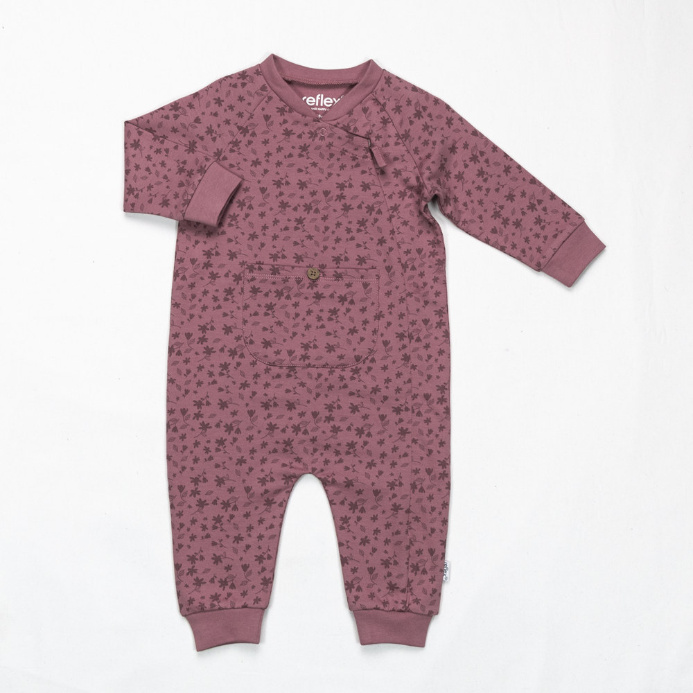 Baby jumpsuit i dus rose med blomstermønster, lange ermer, rund hals, trykknapper og en liten brystlomme.